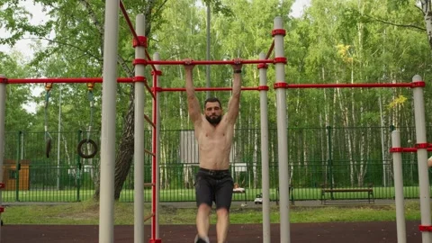 Man Performing Pull-ups at an Outdoor Gym 스톡 동영상 329599244