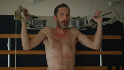 A man is performing pullups in a gym environment, demonstrating strength Stock Footage 284330676