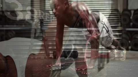 Man performing push-up in gym using fitness tech with network lines and floating Stock Footage 307550088