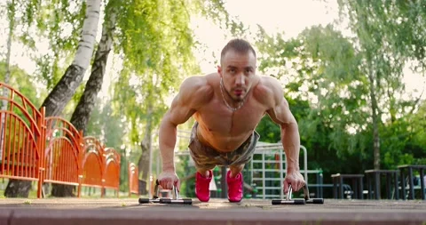Man performing push-ups exercises in park.Muscular sportsman keeping fit Stock Footage 156928817