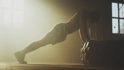 Man performing push ups on tyre Stock-Footage 236193008