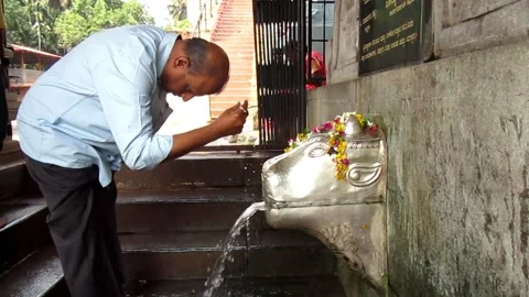 Man performing religious tradition with temple fountain in India Video stock 155026488