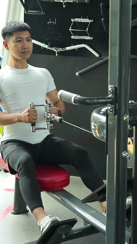 Man Performing Seated Cable Row Exercise in Modern Gym Stock Footage 326849353