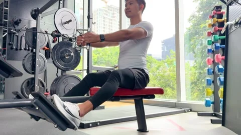 Man Performing Seated Row Exercise in Modern Gym Stock Footage 321581597