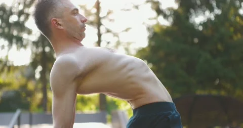 Man performing workout exercise in nature.Gymnast strengthening muscles to feel Stock Footage 158509067