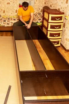 A man performs the assembly of a wardrobe Stock Photos