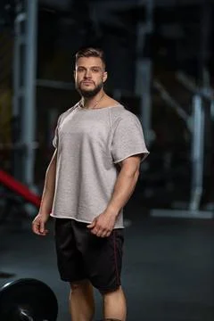 Man performs barbell bicep curl in gym kitchen during workout session at evening Stock Photos