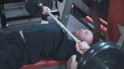 Man performs a bench press in the gym Stock Footage