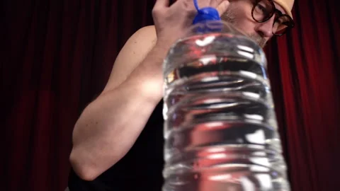 Man performs Bicep curls using a large bottle of water as a weight. Stock Footage 131583671