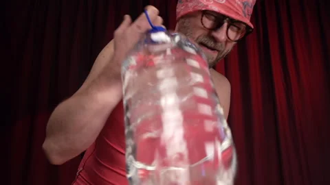Man performs Bicep curls using a large bottle of water as a weight. Stock Footage 133919841