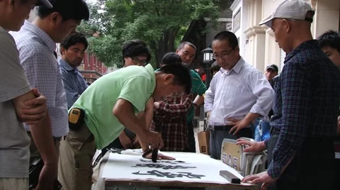 Man performs calligraphy on paper at the street in Beijing, China. Stock Footage 64970001