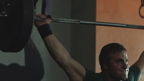 Man performs challenging squats and wipes sweat during workout session Stock Footage 312714025