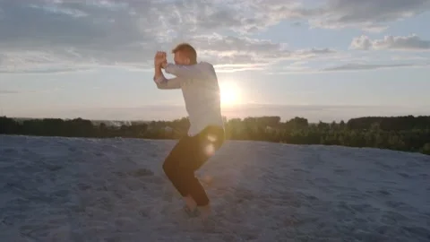 Man performs contemporary choreography on the sand at sunset. Slow motion Stock Footage 135611271