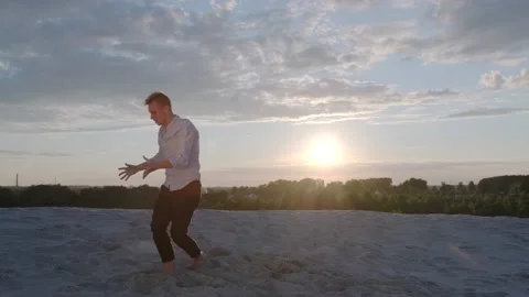 Man performs contemporary choreography on the sand at sunset. Slow motion Stock Footage 135611274