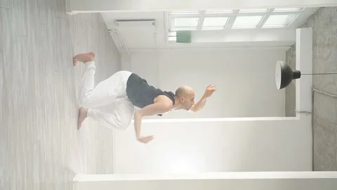 Man performs elements of modern dance from a white studio Stock Footage 169224671