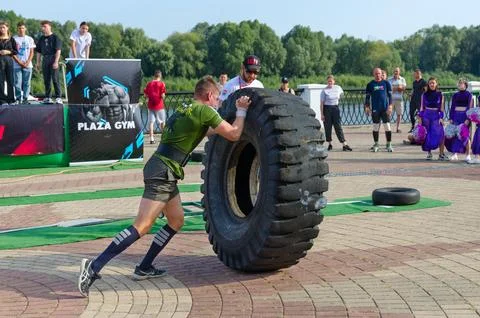 Man performs Exercise Tire Turning during strength competition Stock-Fotos