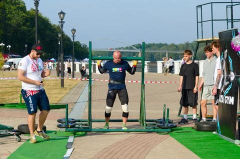 Man performs Exercise Transfer of rocker arm during strength competition Foto stock