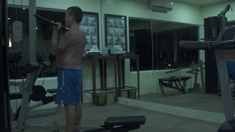 Man performs exercises on the machine at the gym Stock Footage 91332362