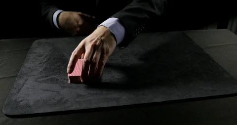 Man performs Faro Shuffle, charlier cut,  then cuts deck of cards into 3 piles. Stock Footage 100786793