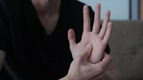 Man performs hand self-massage at home. Close-up view highlights the importance  Stock Footage 327158366
