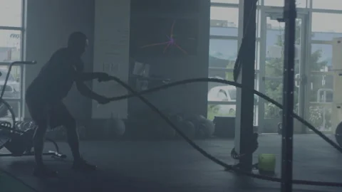 Man performs intense rope workout at gym for strength and endurance training Stock Footage 312707844