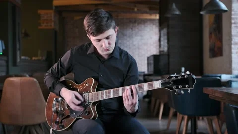 Man performs jazz, blues music on guitar in bar. Retro studio, brick interior Stock Footage 135355946