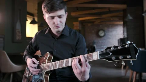 Man performs jazz, blues music on guitar in bar. Retro studio, brick interior Stock Footage 135355962