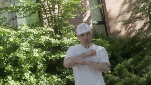 A man performs playful dance moves, mimicking gun gestures with his hands. Stock Footage 283990234