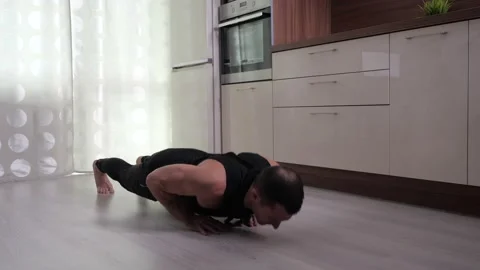 A man performs push-ups from the floor at home. Stock Footage 130992951