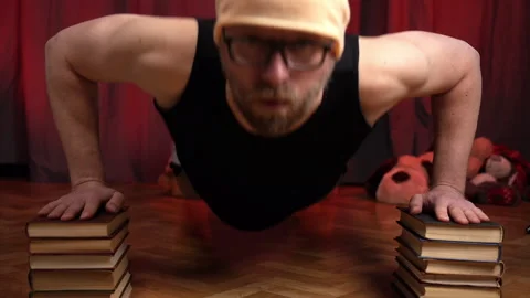 Man performs push-ups using two stacks of books. Stock Footage 131583669