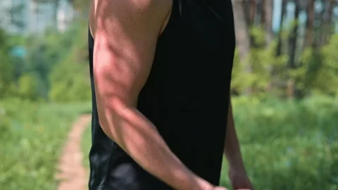 A man performs resistance band exercises outdoors on a sunny day. He Video stock 339016240