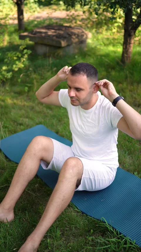 Man performs somatic exercises in the garden in the morning Stock Footage 279248713
