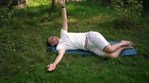 Man performs somatic exercises in the garden in the morning Stock Footage 279248963