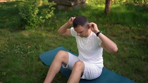 Man performs somatic exercises in the garden in the morning Stock Footage 279249086