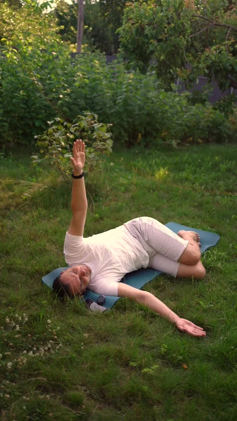 Man performs somatic exercises in the garden in the morning Stock Footage 279249381