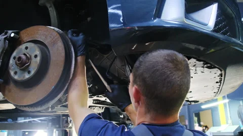 Man performs task to troubleshoot fault near brake disc Video stock 317629130