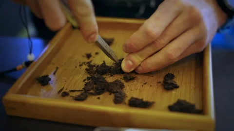 A man performs a tea ceremony and splits Pu'er tea with a special Pu'er tea Stock Footage 296011994