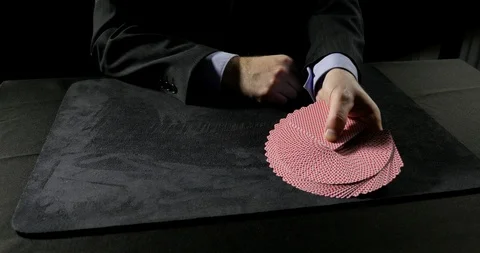 Man performs a variety of cuts with playing cards then fans the cards evenly. Video stock 100786634