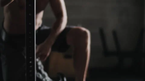 Man performs weight training in gym and unhooks weight ball from his waist Stock Footage 312764470