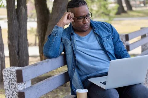 Man performs work in comfortable place outside office thanks modern technology Stock Photos