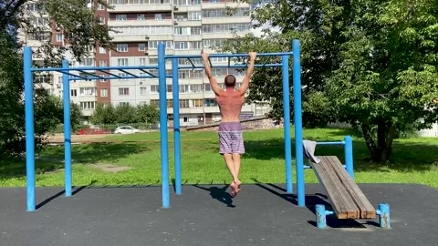 Man performs workout exercises on a horizontal bar, pulls himself up Video stock 160032148