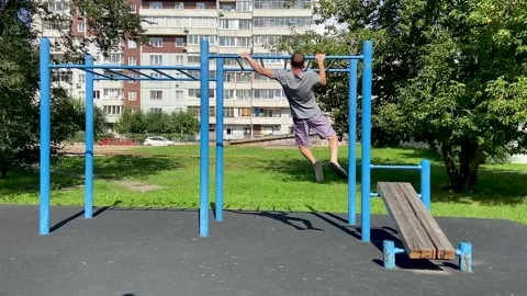 Man performs workout exercises on a horizontal bar, pulls himself up Stock Footage 162018304