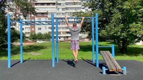 Man performs workout exercises on a horizontal bar, pulls himself up Stock Footage 166314154