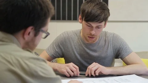 Man with a perplexed look considering drawing, which offers designer. Stock Footage 77489362