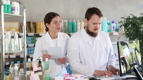 Man pharmacist at computer communicate with girl colleague Stock Footage 327131305