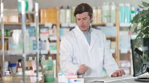 Man pharmacy employee works with computer and notebook dairy. Stock Footage 332641040