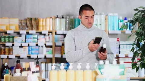 Man in pharmacy scans QR code on antitussive syrup Stock Footage 311837797