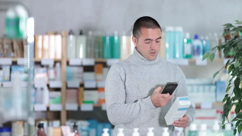 Man in pharmacy scans QR code on emollient for sensitive skin product Stock Footage 317529563