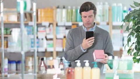 Man in pharmacy scans QR code on antiallergic pills box product Stock Footage 328139658