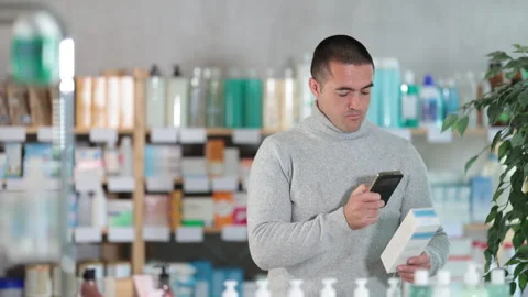 Man in pharmacy scans QR code on emollient for sensitive skin product Stock Footage 342724133